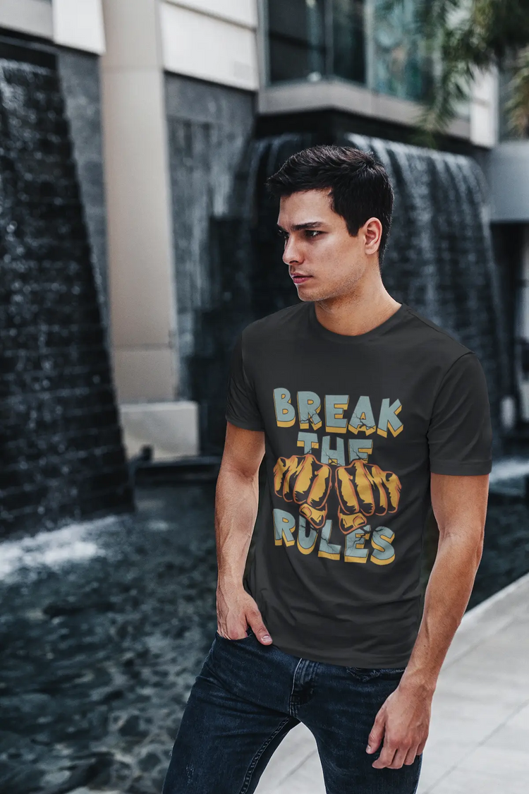 Lässiger Mann in schwarzem Organic Shirt und Jeans steht draußen. Auf dem Shirt ist das blaue BREAK THE RULES Motiv mit zerrissener Schrift und Fäusten zu sehen.