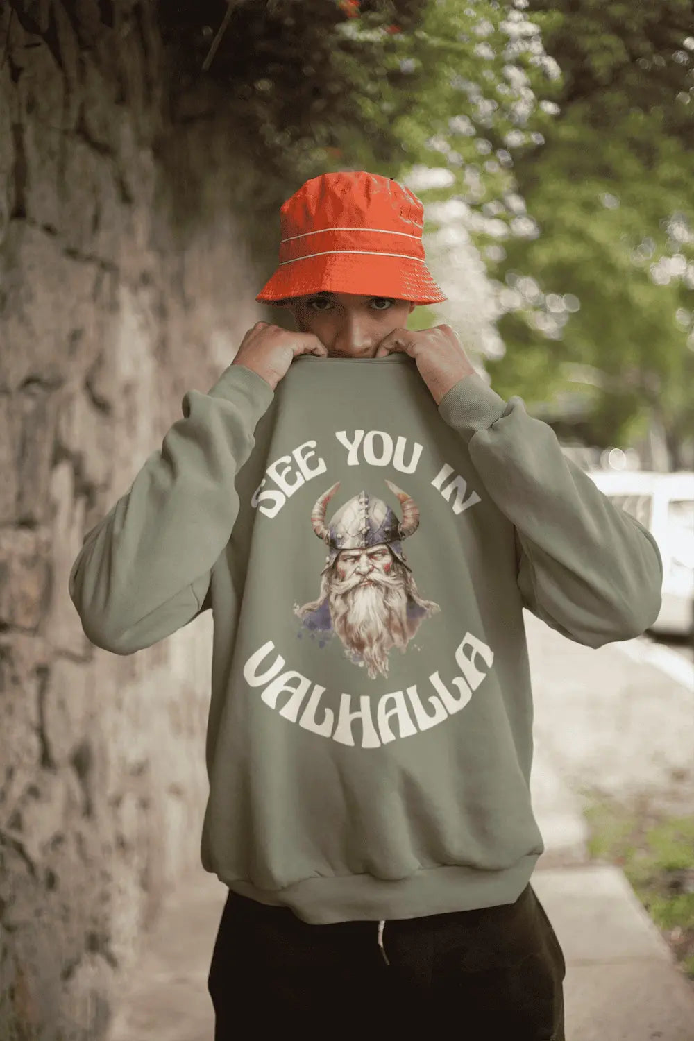 Mann im hellgünen Sweatshirt mit dem Warrior’s Creed Wappen, blonder Wikinger-Bart in Teal und Weiß.